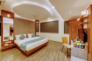Habitación de hotel con cama y TV en Click Hotel by Suba, Jamnagar, en Jamnagar