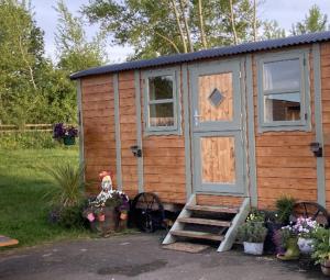 a wooden cabin with a door and some flowers at Captivating 1-Bed Cabin in Middlesbrough in Middlesbrough
