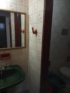 baño con lavabo verde y espejo en El Dorado Deptos a una cuadra del mar en San Bernardo