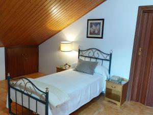 NedaにあるAcogedora casa de campo-PISO Y ATICO con finca-の木製の天井が特徴のベッドルーム1室(大型ベッド1台付)
