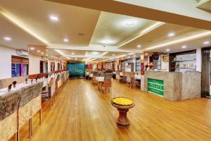 a restaurant with a bar with tables and chairs at Click Hotel by Suba, Jamnagar in Jamnagar