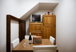 a dining room with a table with a bottle of wine at La Grua House in Castelbuono