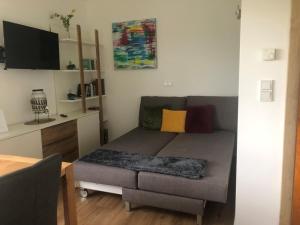 a small living room with a couch and a desk at Residence JORADO in Manning