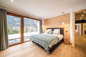 1 dormitorio con cama y ventana grande en Chalet Arande Saint Gervais - by EMERALD STAY en Saint-Gervais-les-Bains