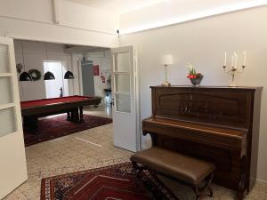 a room with a piano and a pool table at Björnlokan B&B in Munka-Ljungby
