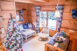una sala de estar con un árbol de Navidad en una cabaña de madera en Chalet Wioska Jagny, en Poronin