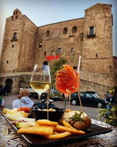 a table with a plate of food and a glass of wine at La Grua House in Castelbuono