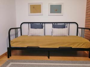 フィゲイラ・ダ・フォズにあるBlue Bird House - BBHの黒いベッド(枕付)が備わる客室です。