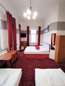 a hotel room with two beds and a desk at Sherwood Hotel Vojkovice nad Ohří in Vojkovice