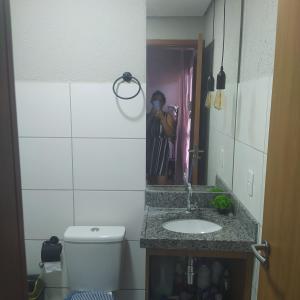 baño con lavabo y una persona que toma una foto en el espejo en Condomínio Villamares en Luis Correia