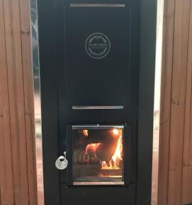 un horno de leña negro con fuego en Lo Boix Le Mas, en Saint-Laurent-de-Cerdans