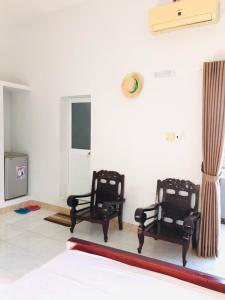 two black chairs sitting in a room with a tv at SUNNY Homestay Mui Ne in Phan Thiet