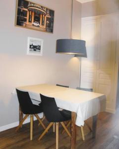 a dining room table with chairs and a lamp at Studio/Patio pour 3 hypercentre! in Le Touquet-Paris-Plage
