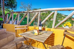 una mesa de madera con 2 copas y una botella de vino en Casa Juana, en Agua de Fontanales