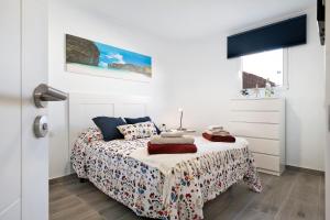 a white bedroom with a bed and a window at Casa Timanfaya in Playa Blanca