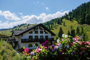 a house on a hill with flowers in the foreground at Casa Baciu Colacu in Fundu Moldovei