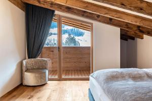 a bedroom with a bed and a large window at Alpin Chalet Samer Apt Fürstenblick in Sarntal