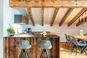 a kitchen with wooden floors and a table with chairs at Alpin Chalet Samer Apt Fürstenblick in Sarntal