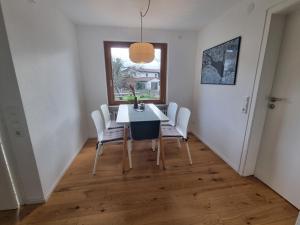 uma sala de jantar com uma mesa e cadeiras e uma janela em Traumhafte Gartenwohnung in Überlinger Hanglage - Zur goldenen Kiwi em Überlingen