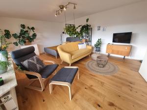 uma sala de estar com um sofá e uma televisão em Traumhafte Gartenwohnung in Überlinger Hanglage - Zur goldenen Kiwi em Überlingen