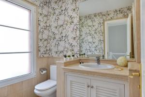 a bathroom with a sink and a toilet and a mirror at Chalet Santa Ana 15 by VillaGranCanaria in Playa del Ingles