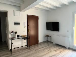 een lege kamer met een deur en een tv aan een muur bij Terrazza Montegrappa in Reggio Emilia