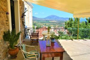 a patio with a table and chairs on a balcony at Soubassis House in Elíka