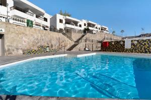 une grande piscine devant certains appartements dans l'établissement Esther Dream Bungalow, à Mogán