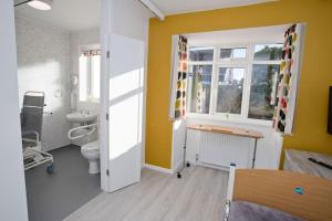 ein Bad mit einem Waschbecken, einem WC und einem Fenster in der Unterkunft Hilda's Retreat Accessible wheel chair friendly with hoist in Parkstone