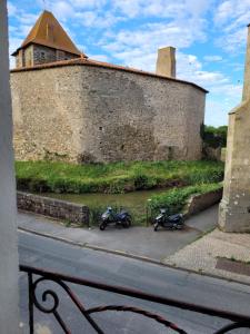 two motorcycles parked in front of a wall at Le Logis du Donjon 1 in Les Herbiers +2 photos