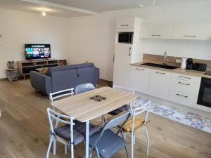 een keuken en een woonkamer met een houten tafel en stoelen bij Le Logis du Donjon in Les Herbiers