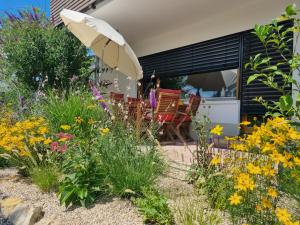 um jardim com flores e um guarda-sol em Traumhafte Gartenwohnung in Überlinger Hanglage - Zur goldenen Kiwi em Überlingen