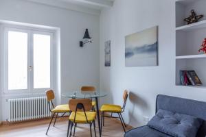 sala de estar con mesa, sillas y sofá en Easylife - Accogliente e moderno bilocale in zona Navigli, en Milán