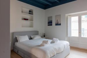 - une chambre blanche avec un grand lit et des serviettes dans l'établissement Easylife - Accogliente e moderno bilocale in zona Navigli, à Milan