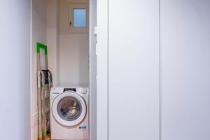 una sala de lavandería con lavadora en una habitación en Easylife - Accogliente e moderno bilocale in zona Navigli, en Milán