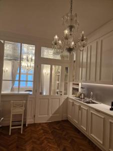 a kitchen with white cabinets and a chandelier at AB Ljubljana - Breg Apartments in Ljubljana