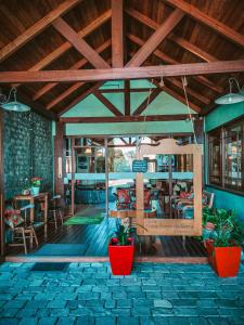 Habitación grande con techos de madera, mesas y plantas. en Hotel Aconchego da Serra en Gramado