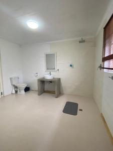 a bathroom with a toilet and a monitor on the wall at Mon Desir in Pietermaritzburg