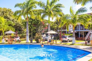 a person swimming in a pool with palm trees at Qavi - Casa fantástica no condomínio Vista Hermosa #CasaNanu09 in Pipa