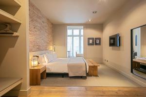 a bedroom with a bed and a brick wall at Colectia Stays Pau Claris in Barcelona