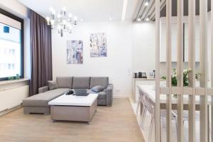 EXCLUSIVE Aparthotel في وارسو: غرفة معيشة مع أريكة وطاولة