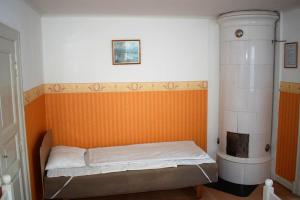 VenaにあるHus Venaのオレンジ色の壁の客室の小さなベッド1台分です。