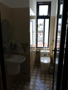 uma casa de banho com um WC, um lavatório e uma janela em K Bình Phương Hotel em Da Lat