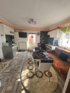 een keuken en een woonkamer met een tafel en een bank bij Casa Doina in Rîşnov