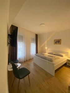 a bedroom with a bed and a chair at Prenoćište Stari Grad - Old Town in Tuzla +45 photos