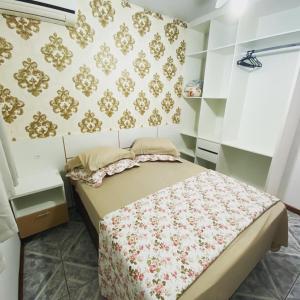 um quarto com uma cama num quarto com papel de parede em Res. SeibertBarreto em Florianópolis