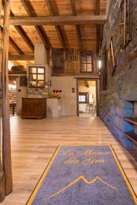 Frassinetto的住宿－La Mason dla Grà，铺有木地板的谷仓,铺着蓝色地毯