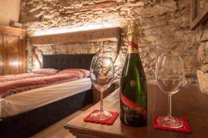 a bottle of champagne and two glasses on a table at La Mason dla Grà in Frassinetto