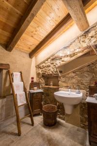 a stone bathroom with a sink and a toilet at La Mason dla Grà in Frassinetto