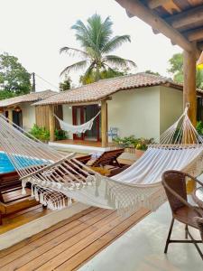 a patio with two hammocks and a house at Suites Taipe in Trancoso